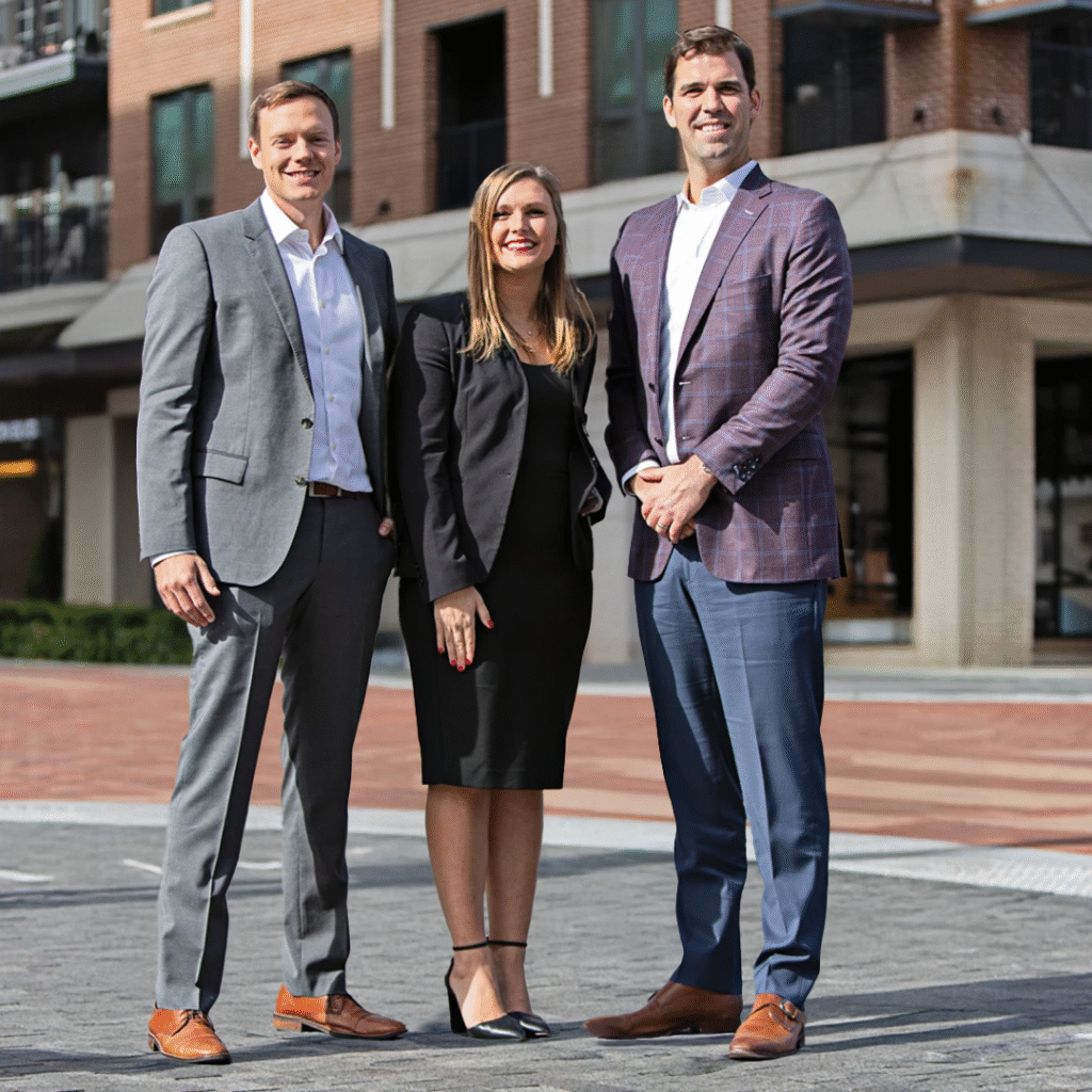 Merchants Capital Executives Brian Sullivan | EVP, COO; Julie Sharp | EVP, Tax Credit Equity; and Mike Dury | President and CEO standing on the sidewalk outside of HQ1 in Carmel, IN